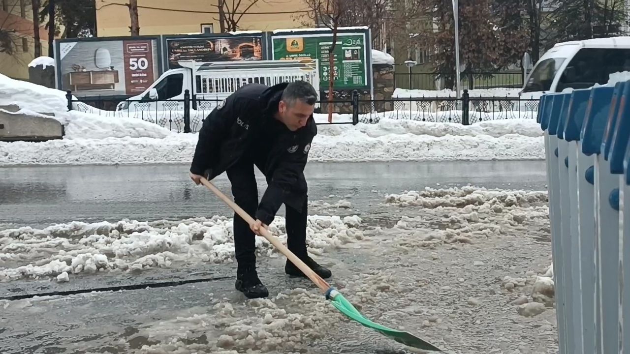 Muş'ta polisten örnek davranış: Su dolan caddeyi kürekle temizledi