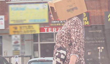 Başına karton kutu geçirerek sıcaktan korunmaya çalıştı