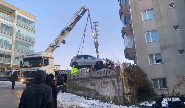 Buzlanan yolda kayan otomobil apartmanın bahçesine düştü