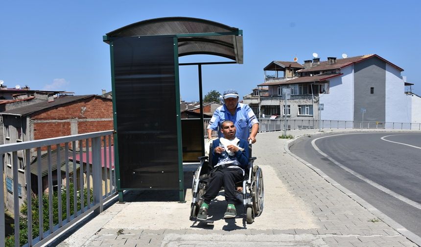 Engelli Oğlu Araçları İzleyebilsin Diye Her Gün Saatlerce Otobüs Durağında Oturuyor